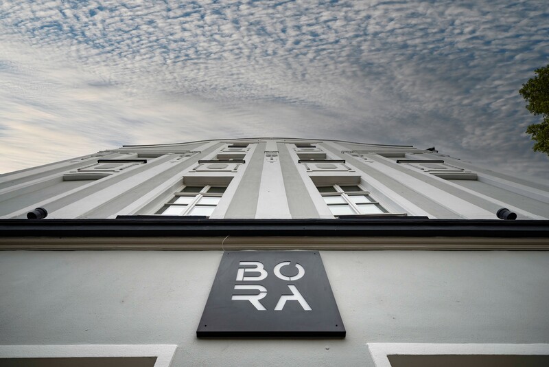 Ansicht der Fassade mit dem Logo des BORA, steil von unten nach oben fotografiert. Blauer Himmel mit Wolken.