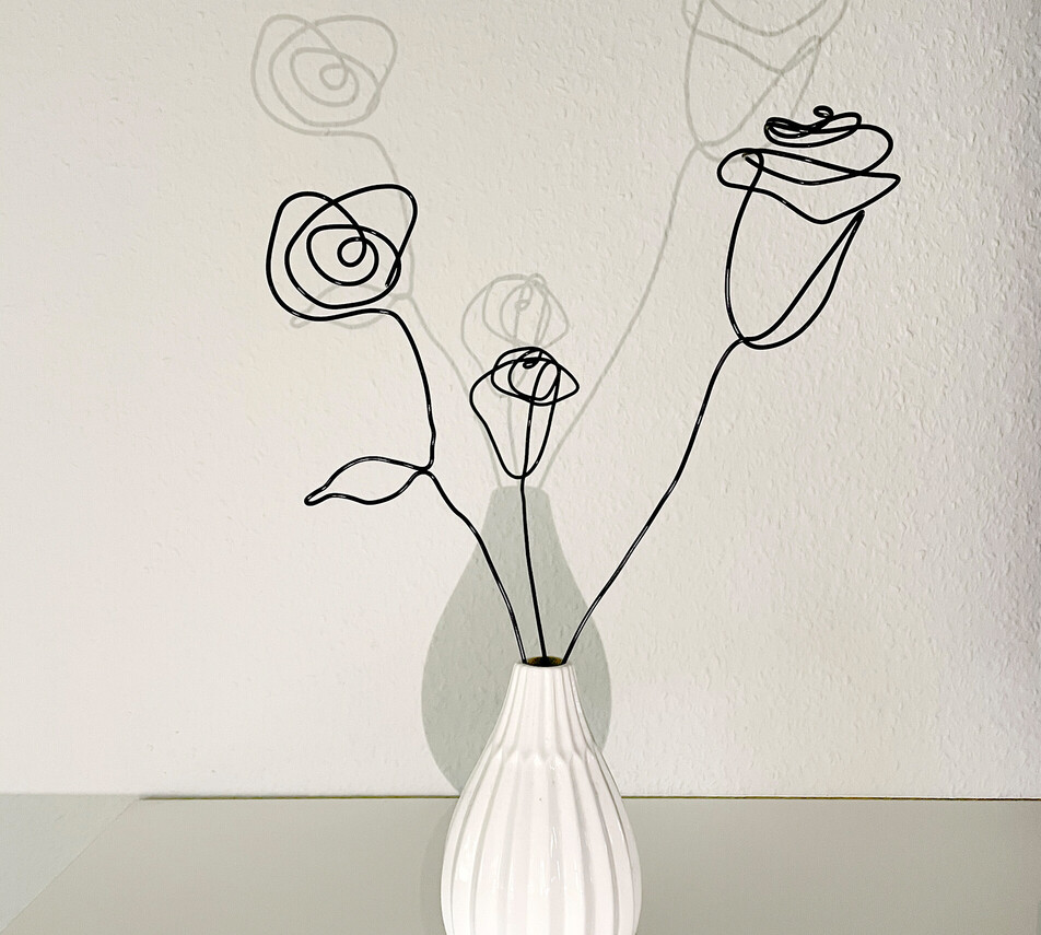 Rosen aus Draht in einer weißen Vase.